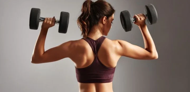 Strong woman lifts dumbbells in gym by Beautiful things on @creativemarket
